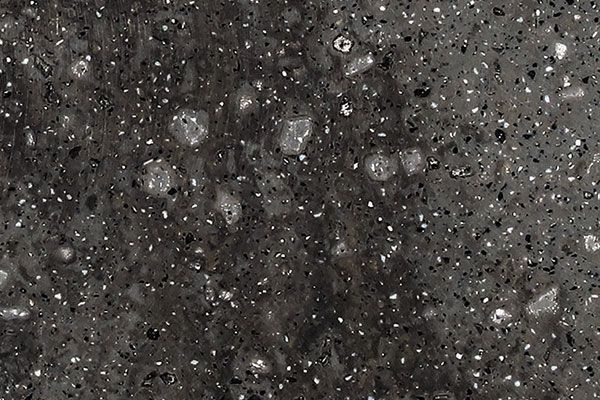 Dark gray speckled surface with light-colored inclusions.