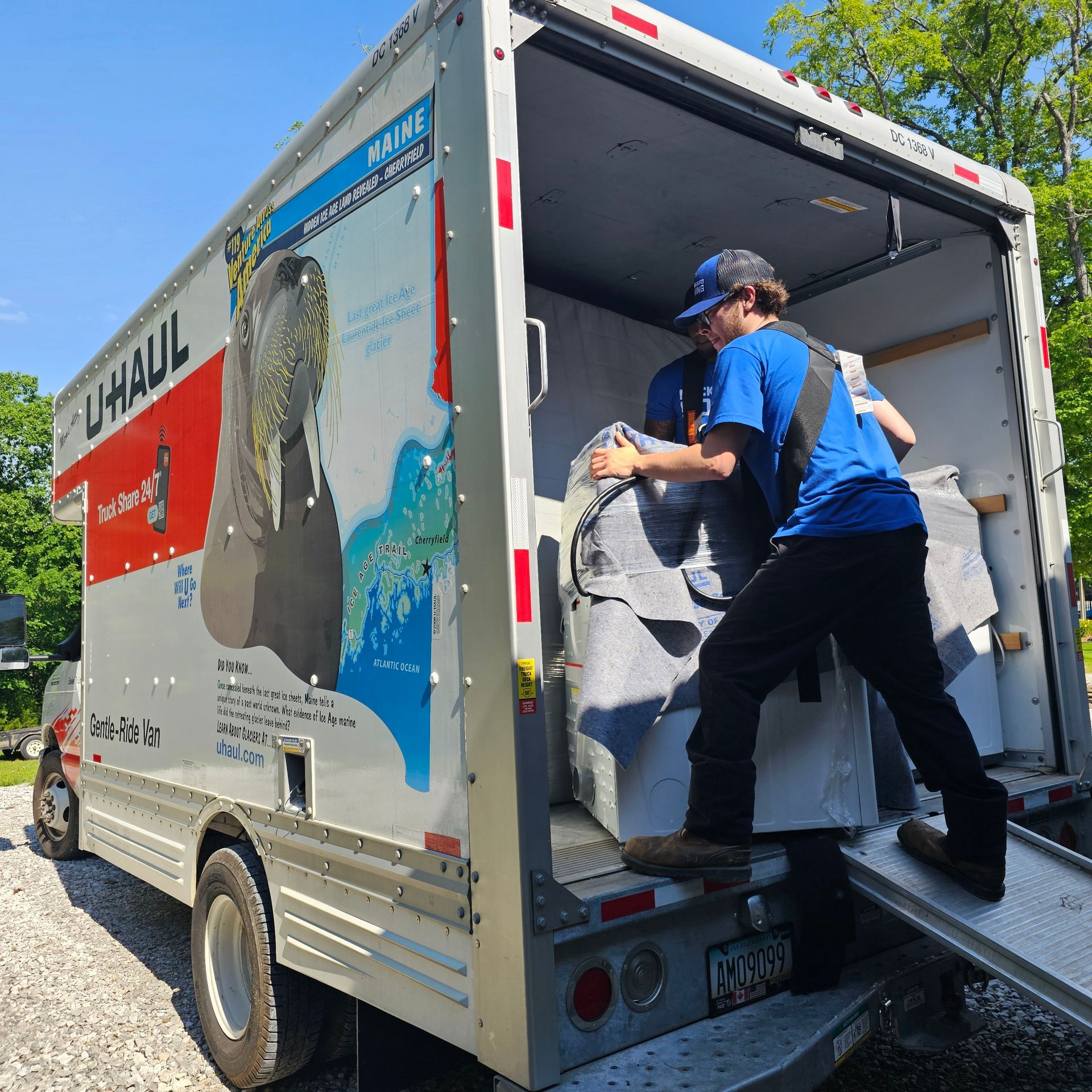 Two Delivery Men Are Loading Boxes Into A Van - Fayetteville, AR - Mockingbird Moving