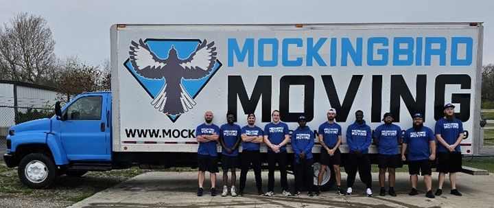 A Group Of People Standing In Front Of A Mockingbird Moving Truck - Fayetteville, AR - Mockingbird Moving