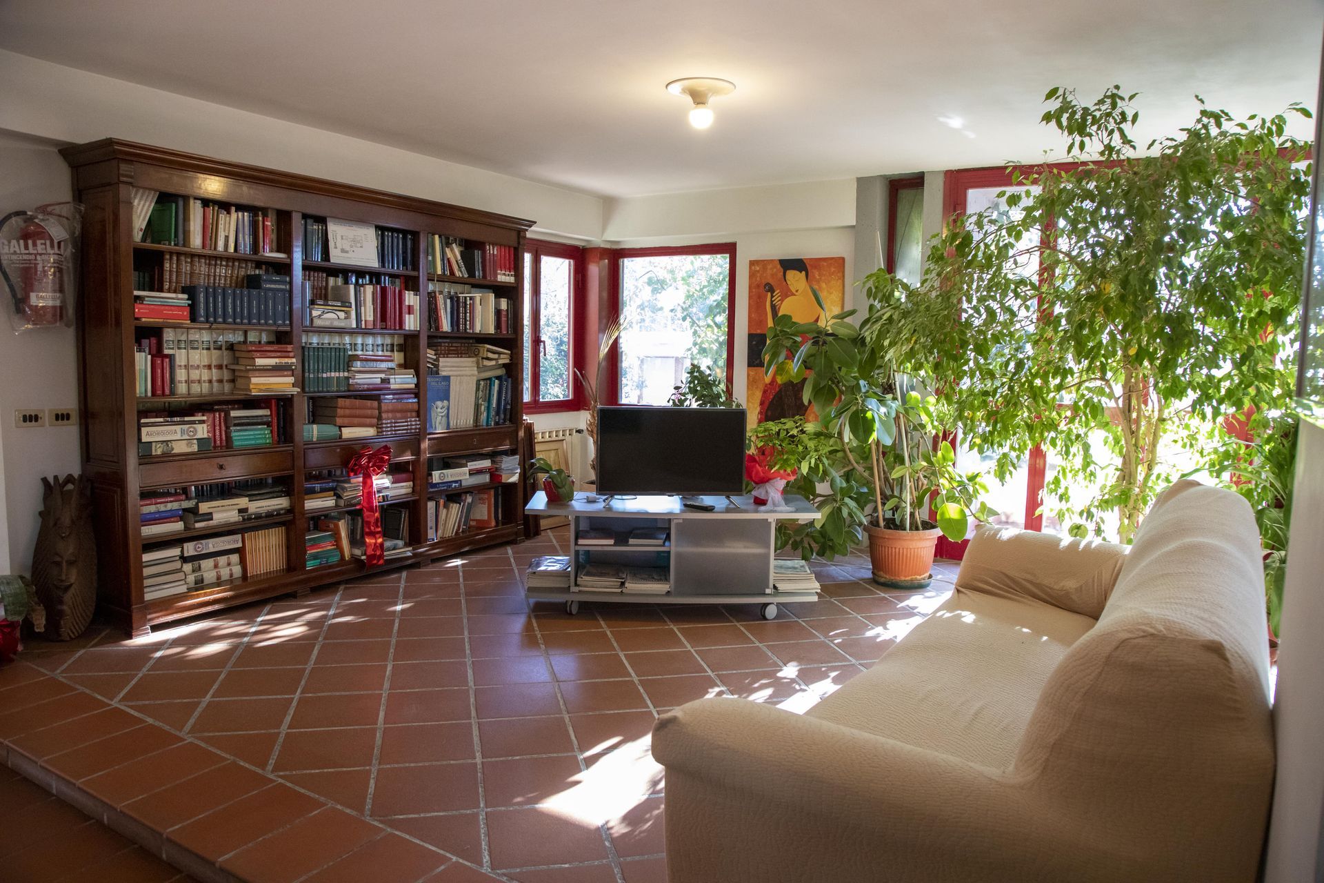 Un soggiorno con divano, libreria e televisione.