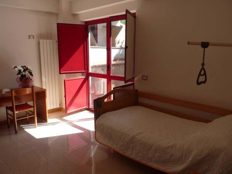 Una camera con un letto e una porta rossa