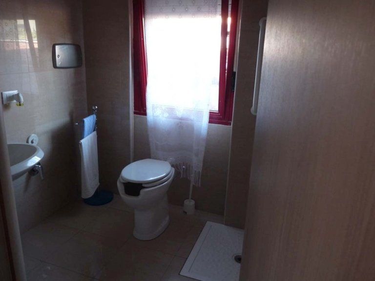 Un bagno con wc, lavandino e finestra