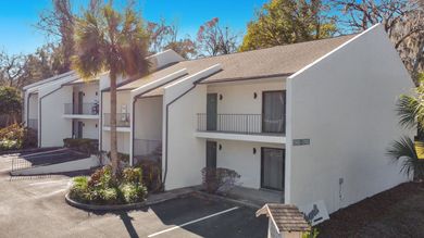 A white apartment building with a parking lot in front of it