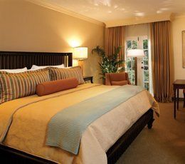 A hotel room with a large bed and a chair