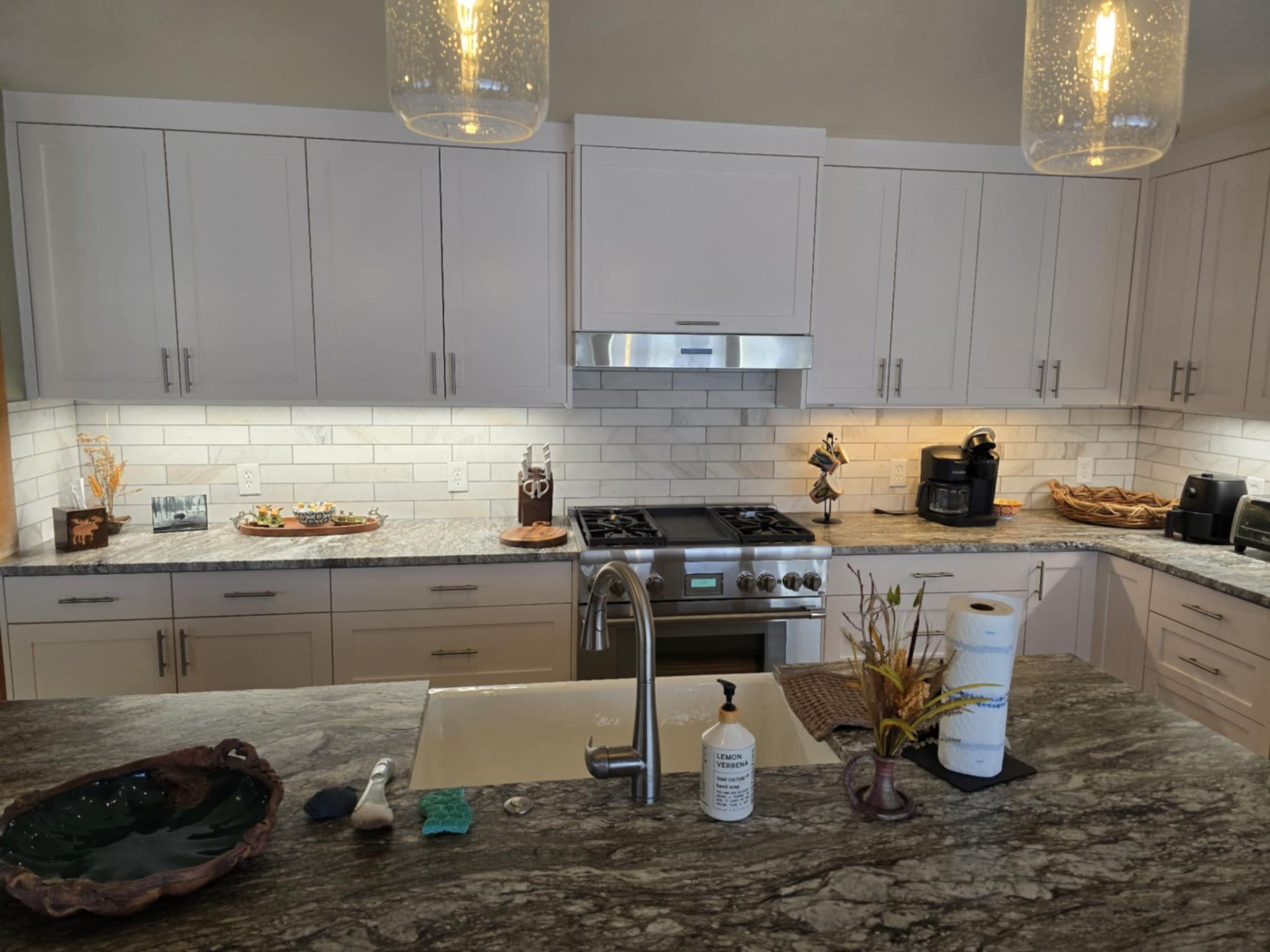 Modern kitchen with white cabinets, granite countertops, and stainless steel appliances.