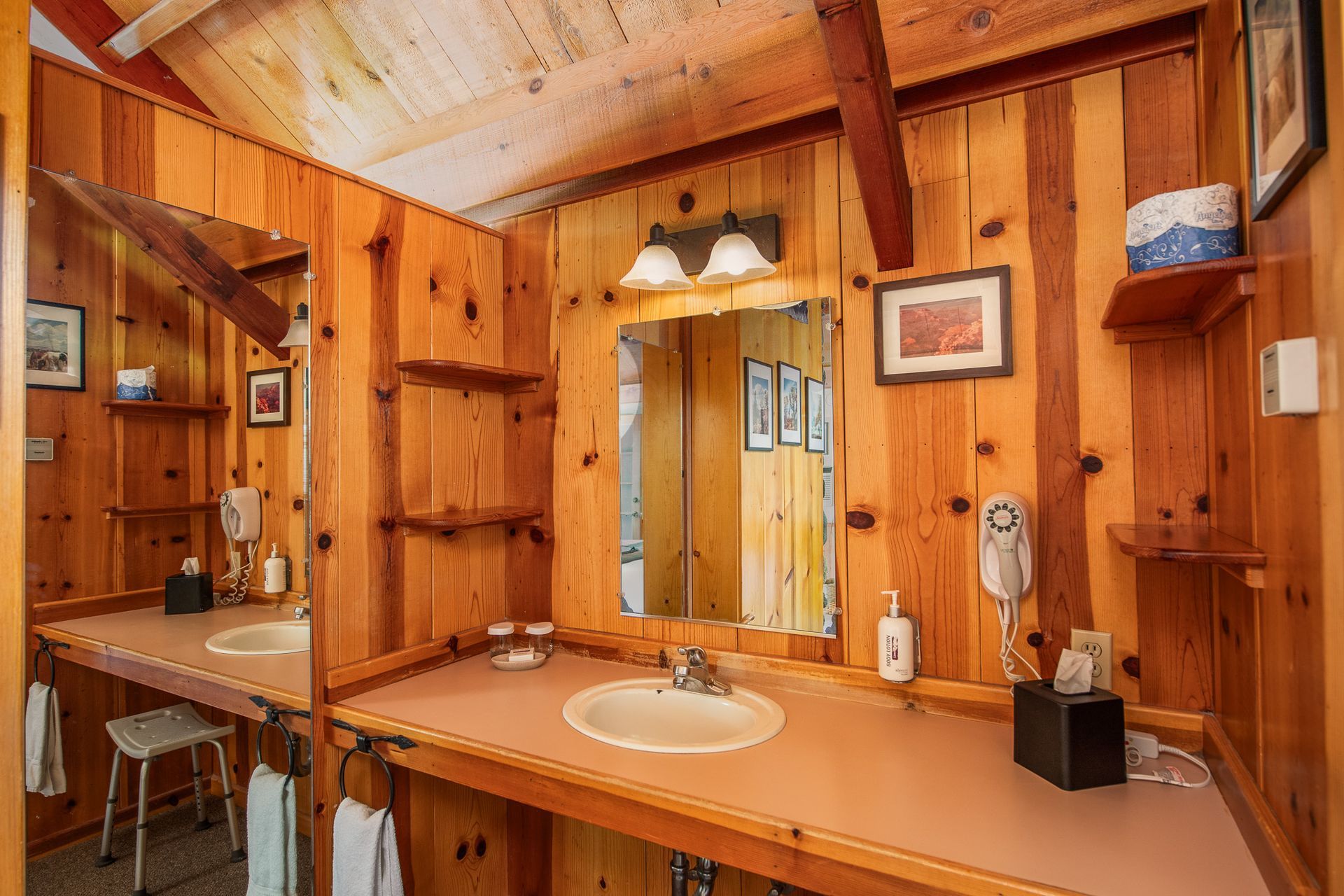 Wooden bathroom with sink, mirror, and small shelves.