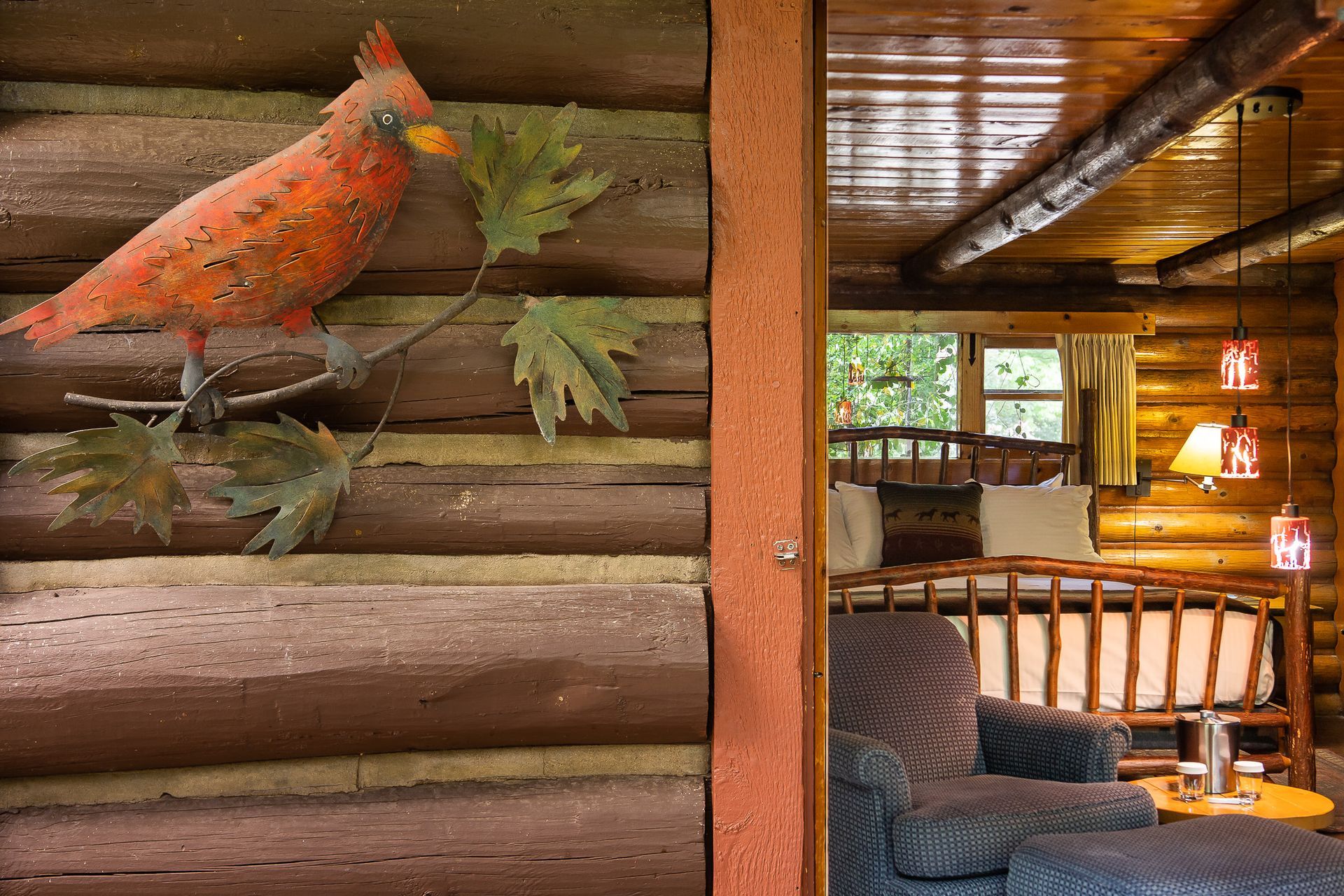 Rustic cabin interior with a cardinal decoration and a view of the bedroom.