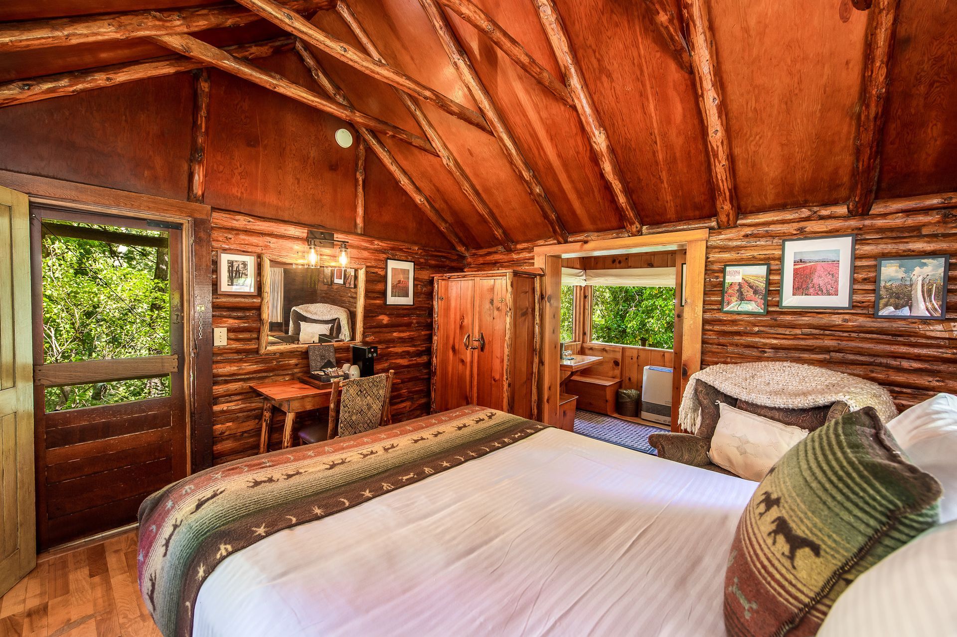 Cozy log cabin bedroom with a bed, window, and wooden walls.