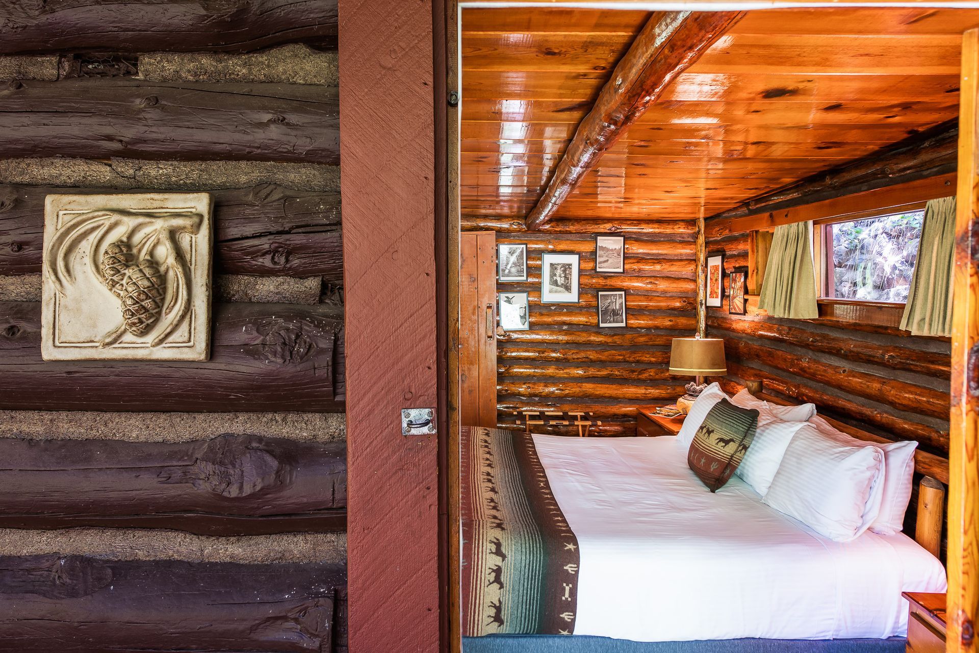 Bedroom interior of a log cabin with a bed, artwork, and natural wood.