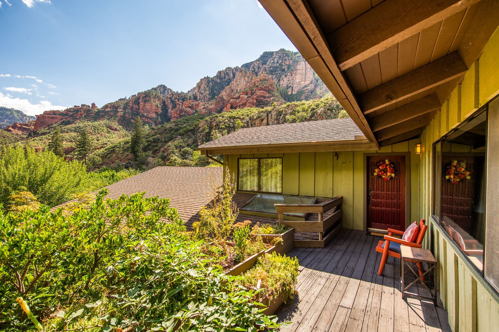 Deck of a home with mountain views, hot tub, and greenery.