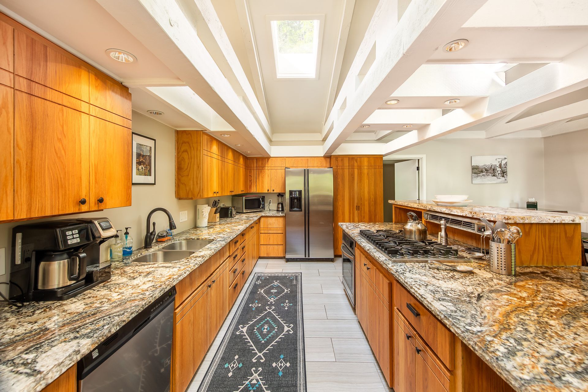 Kitchen with wood cabinets, granite countertops, and a central island. Includes stainless steel appliances.