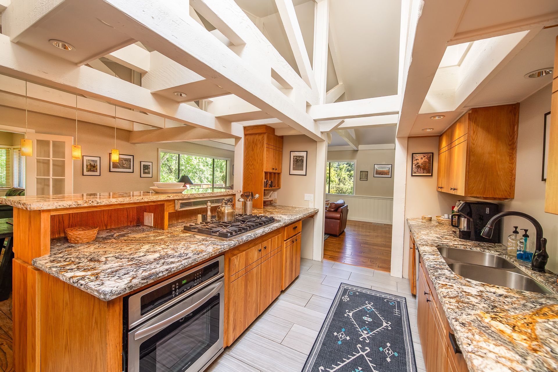 Kitchen with wooden cabinets, granite countertops, and skylights.