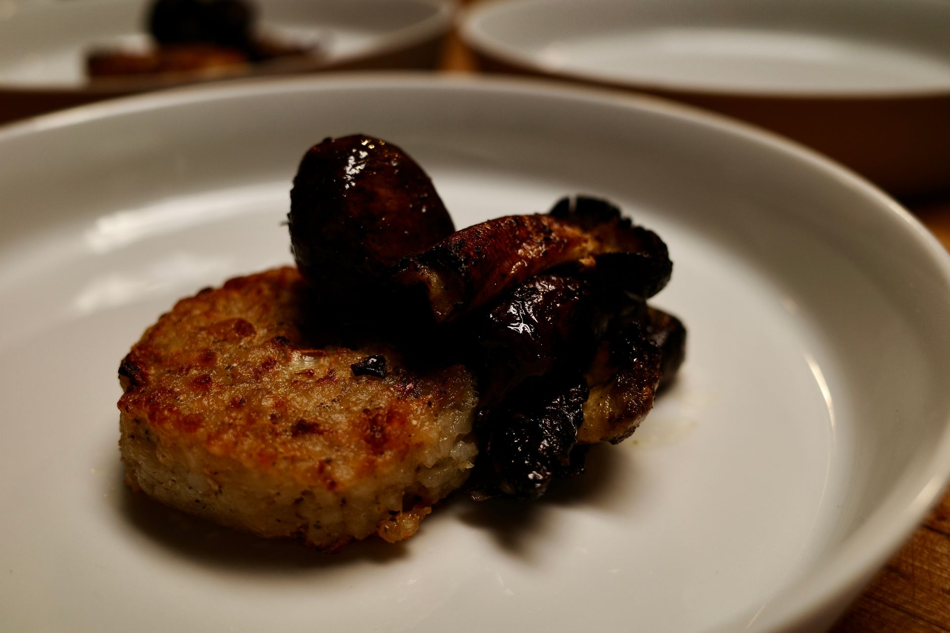 Sautéed mushroom and browned patty in a white bowl.