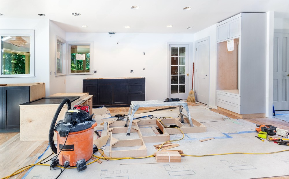 a vacuum cleaner is sitting on the floor of a living room under construction .