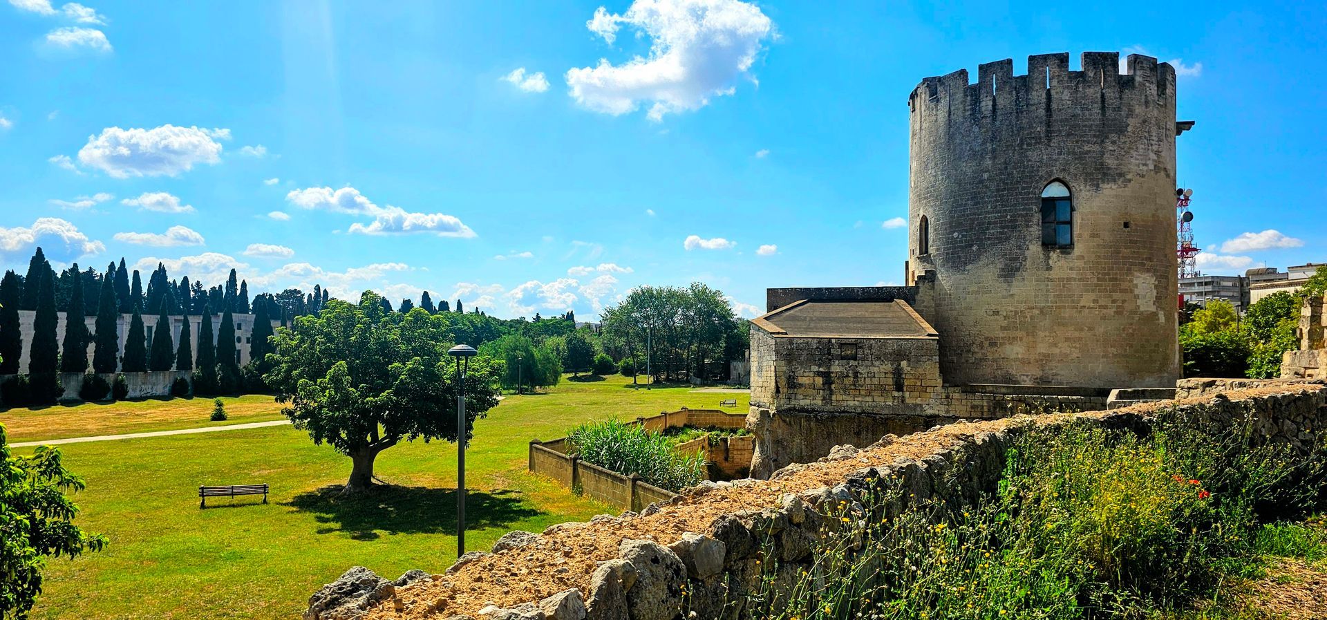 Parco di Belloluogo's castle tower is sitting on top of a grassy hill in the back corner of the park.