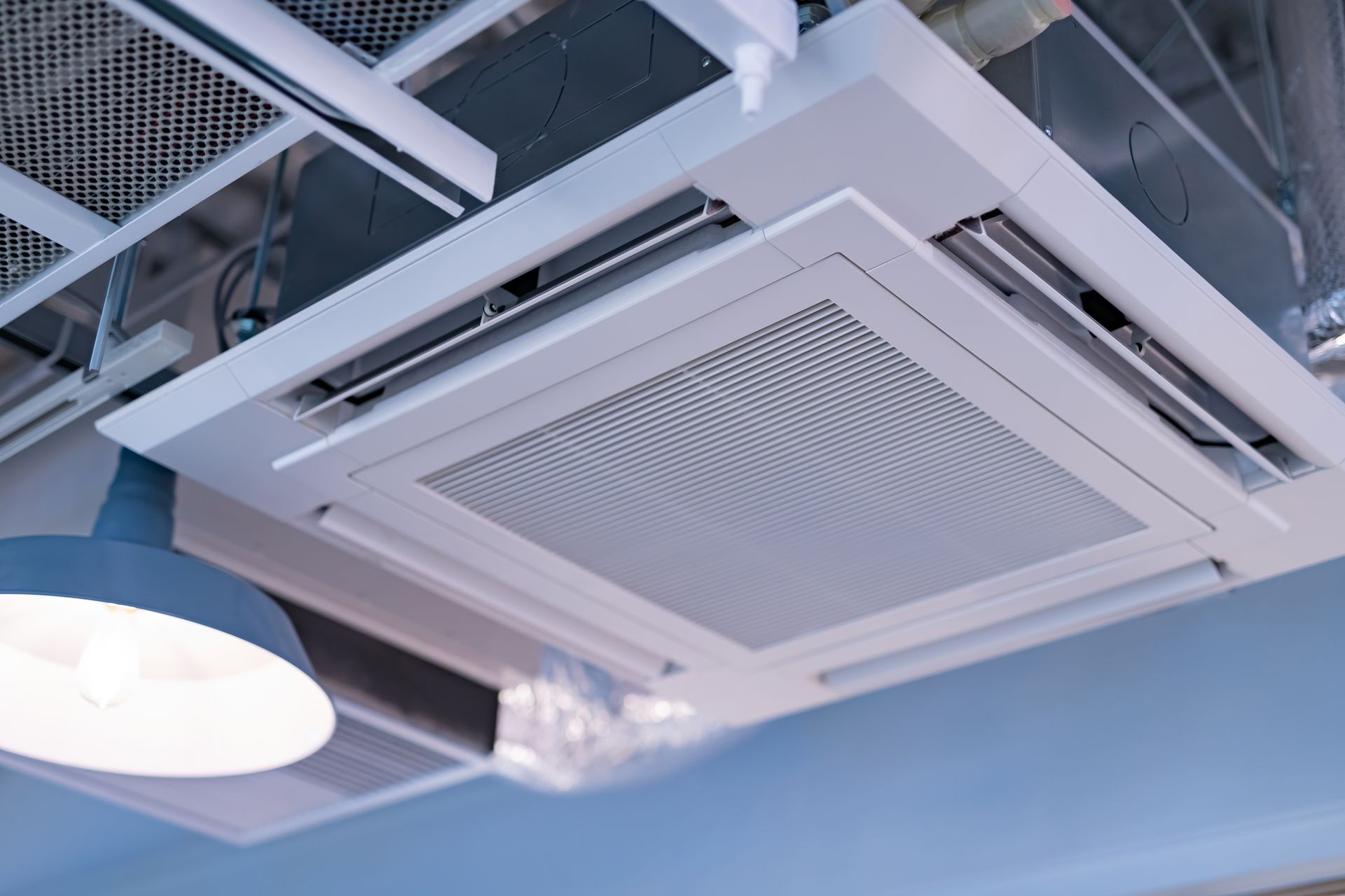 A close up of a ceiling mounted air conditioner in a room.