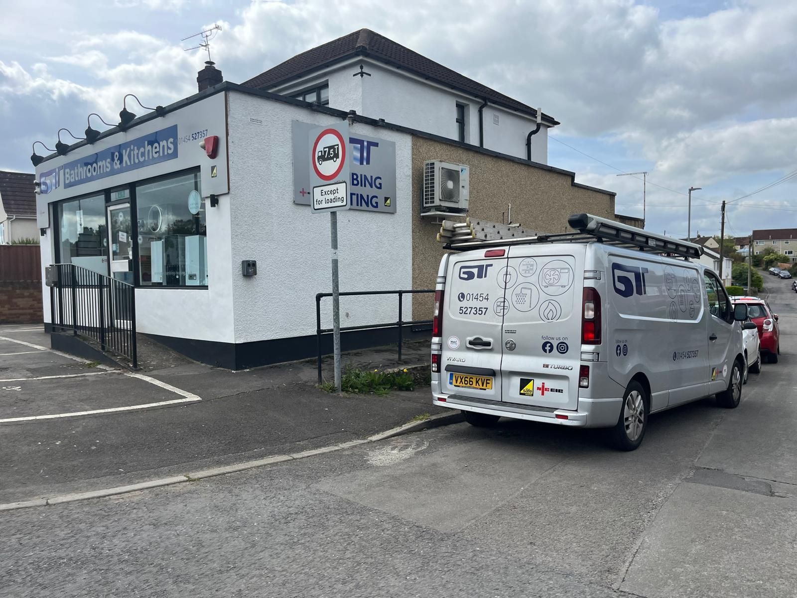 A white van parked outside a shop, 