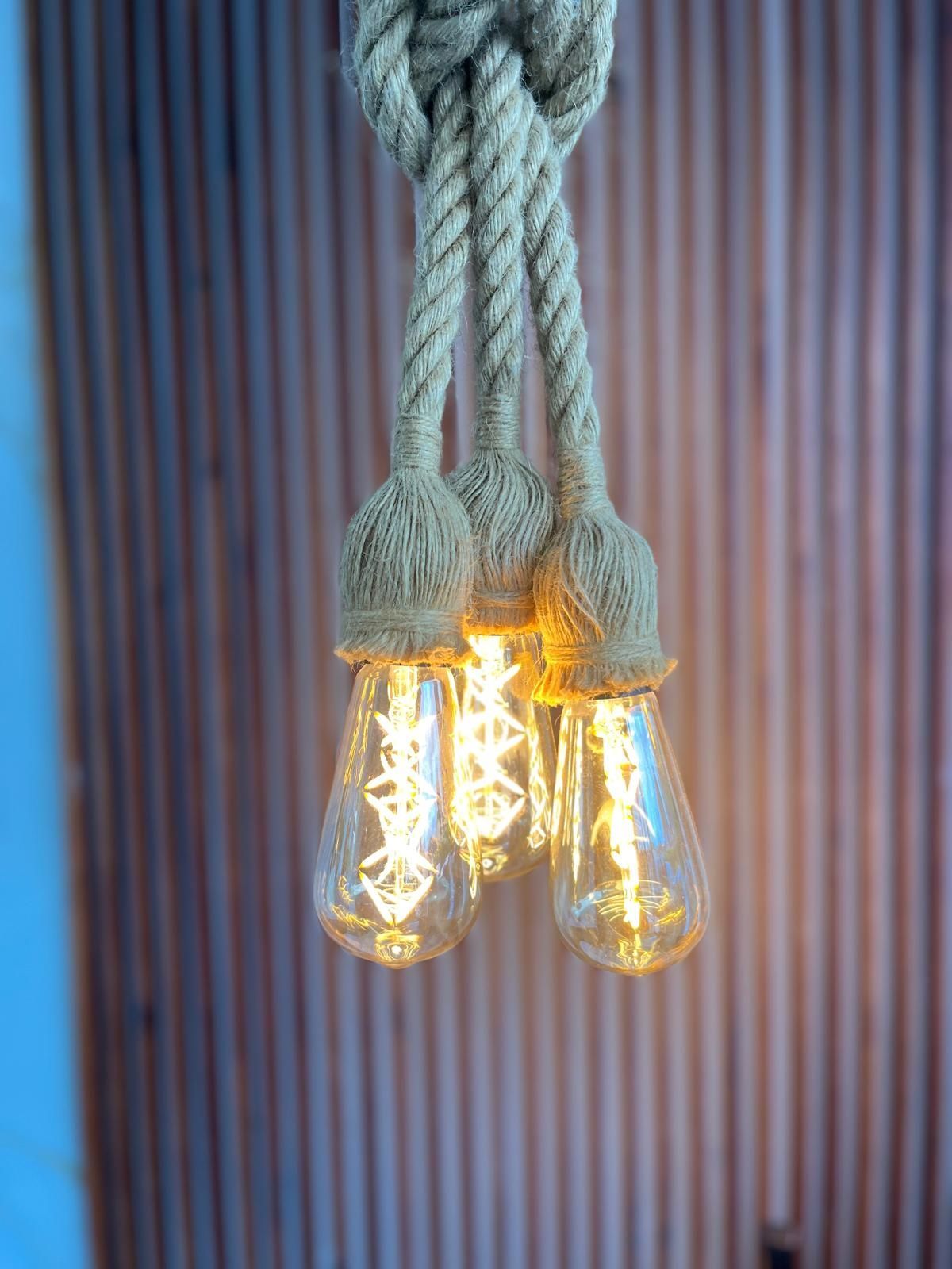 A close up of three light bulbs hanging from a rope.