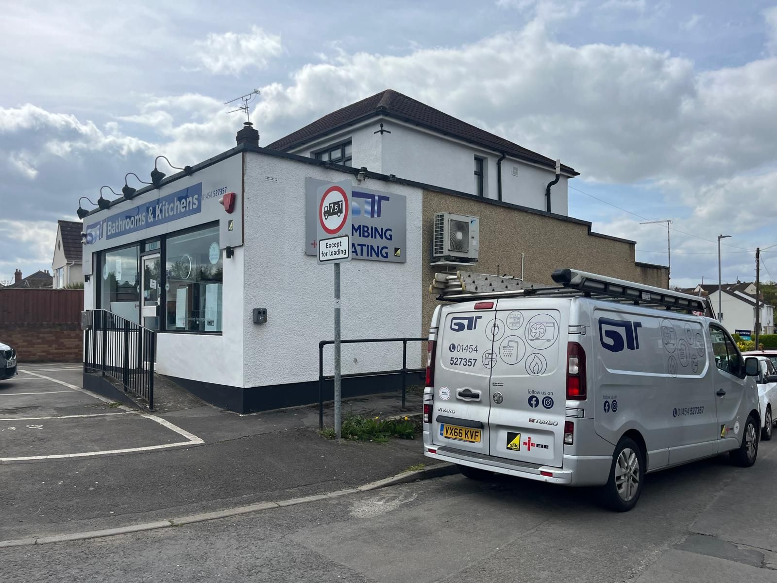 A GT Plumbing and Heating van is parked outside their showroom