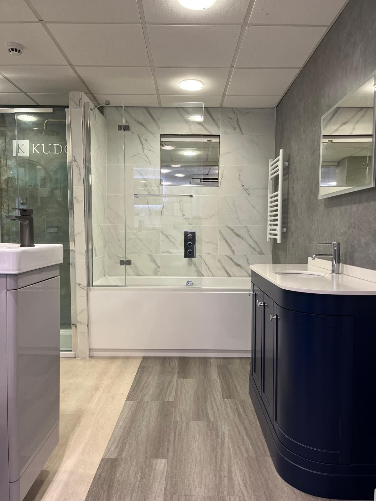 A bathroom with a bathtub , sink and mirror.