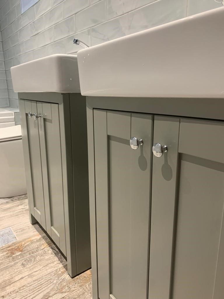 A bathroom with two sinks and two cabinets.