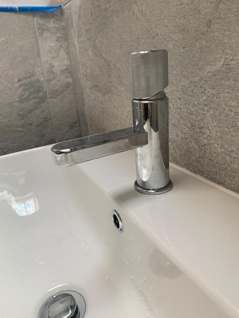 A close up of a bathroom sink with a chrome faucet.