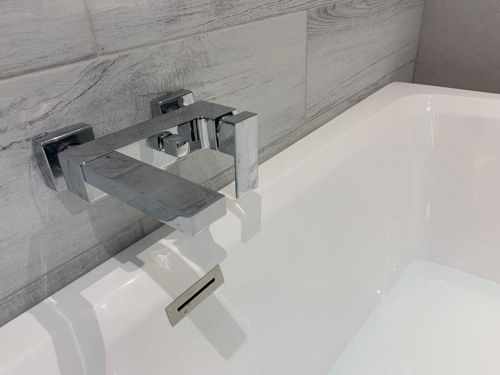 A close up of a bathtub faucet in a bathroom.