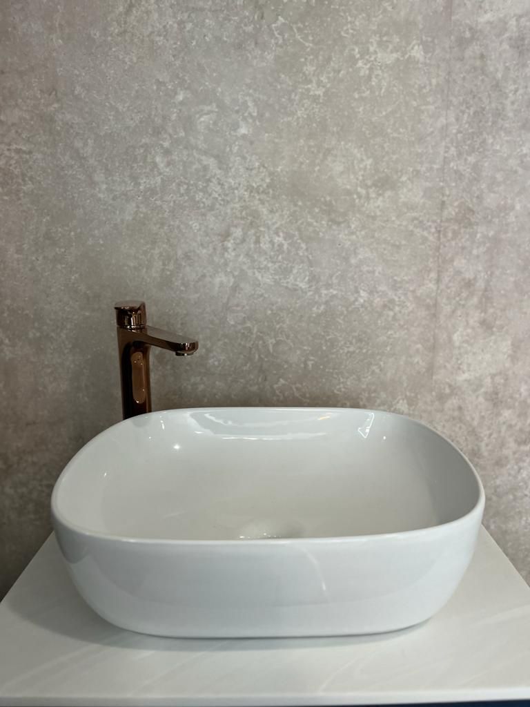 A white sink is sitting on top of a white counter.