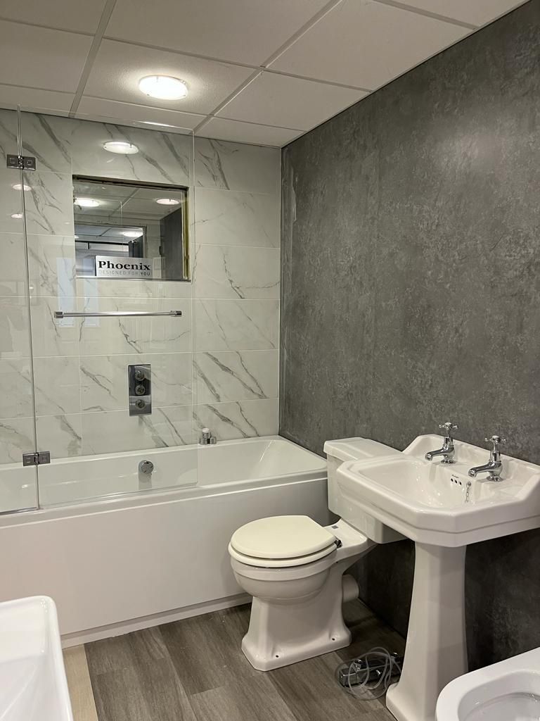 A bathroom with a toilet , sink and bathtub.