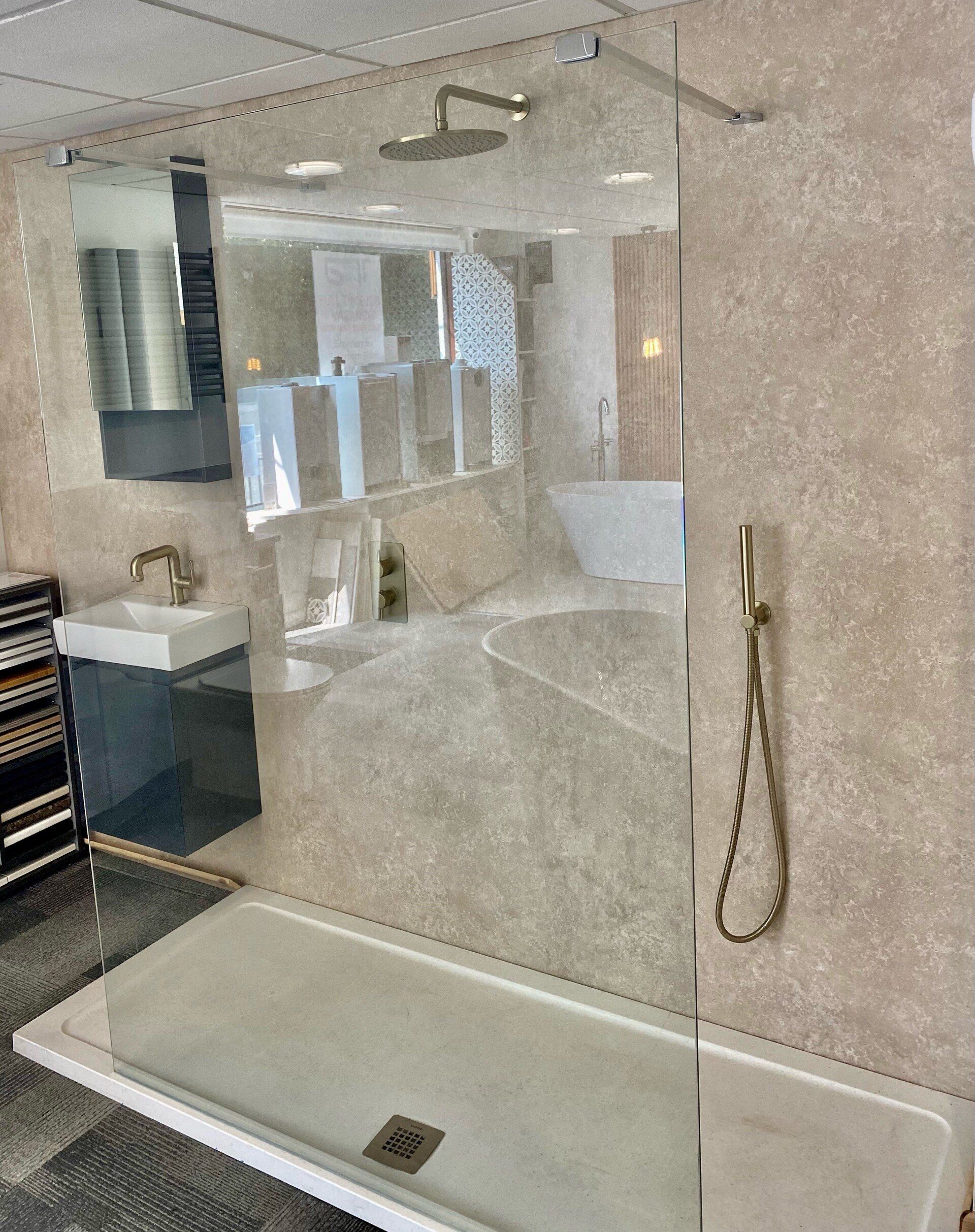 A bathroom with a walk in shower and a sink