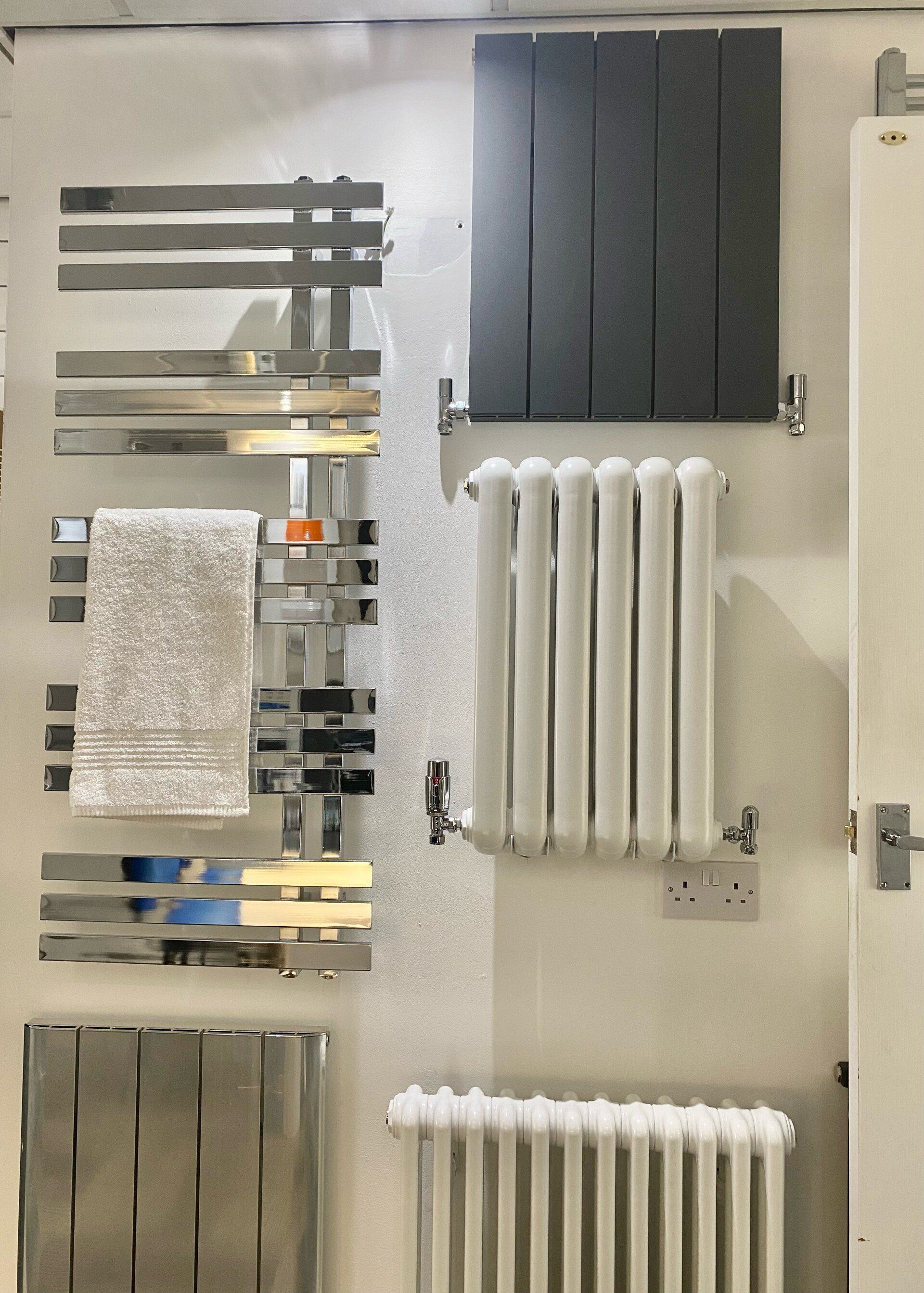 A display of radiators and towel racks in a bathroom