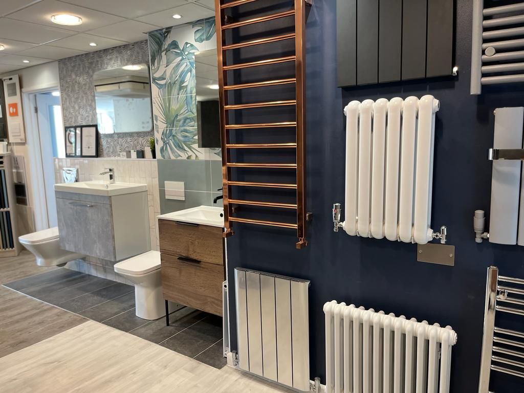 A bathroom with a sink , toilet , and radiators.