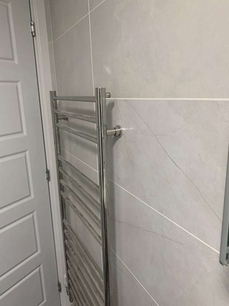 A towel rack is hanging on a wall in a bathroom next to a door.