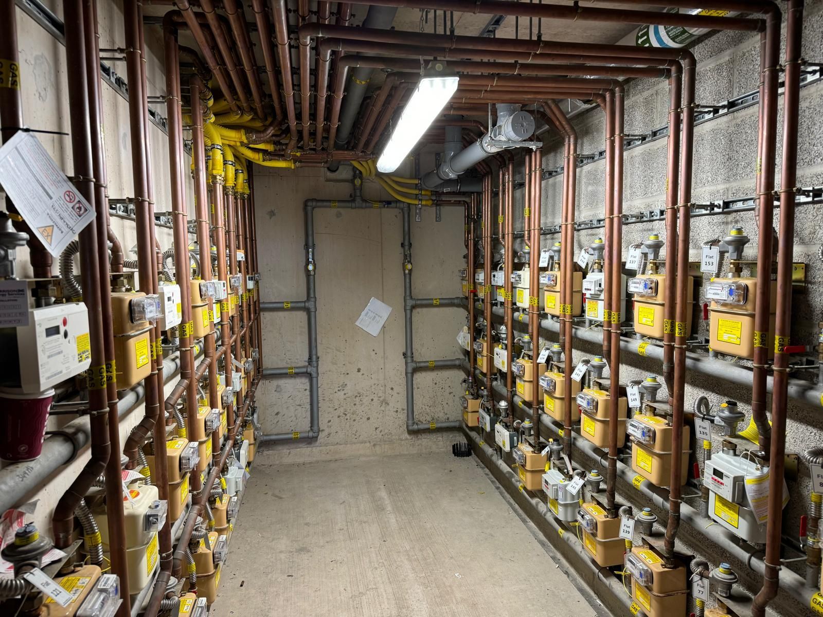 A row of stainless steel pipes and valves in a factory.