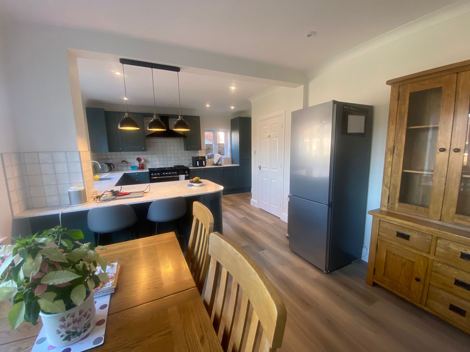 A kitchen with a table and chairs and a refrigerator.