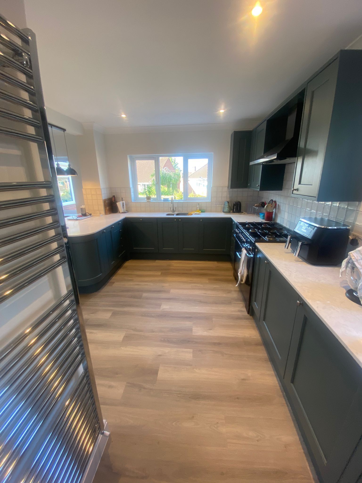 A kitchen with a stove , sink , and toaster oven.
