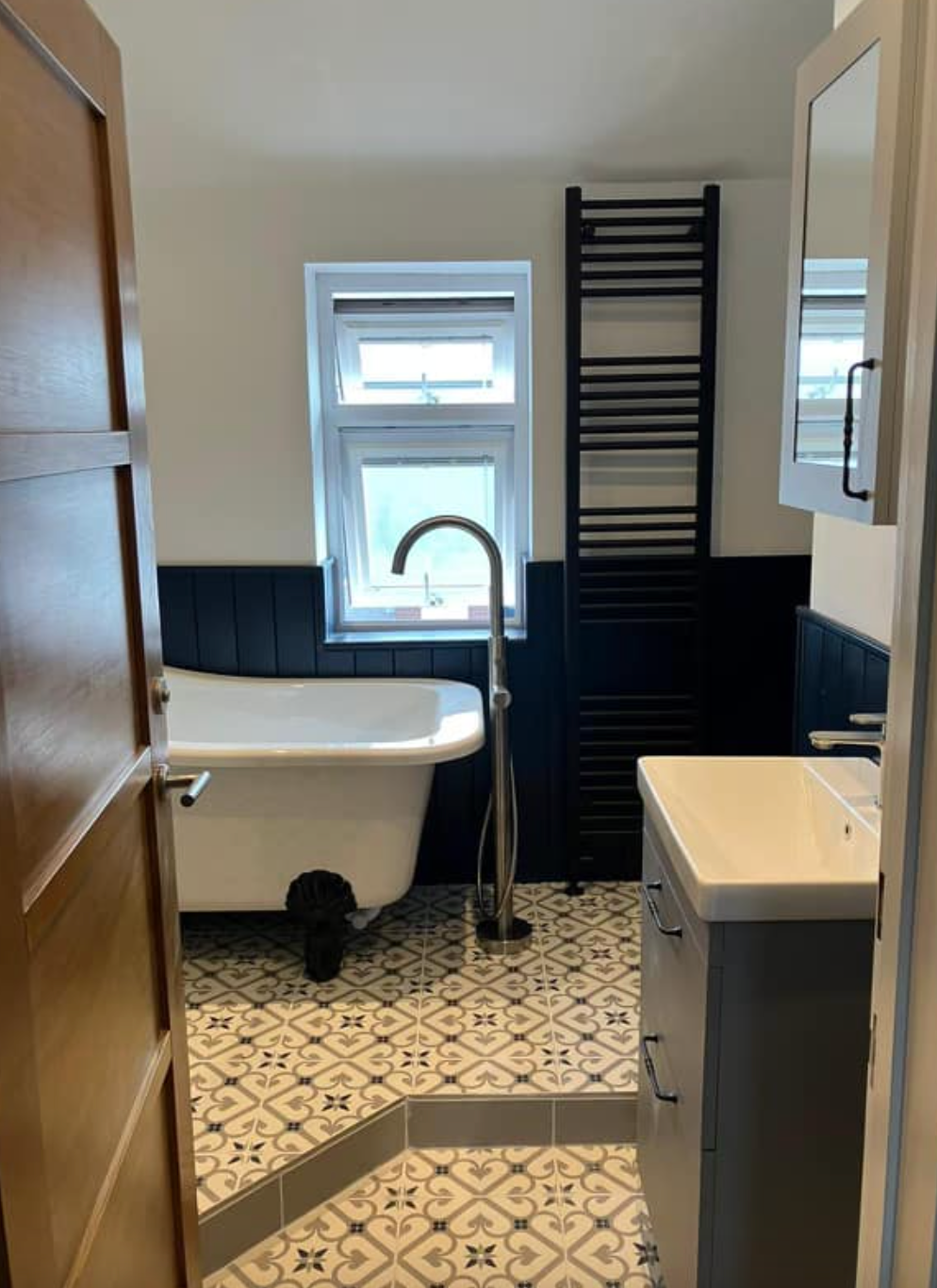 A bathroom with a bathtub , sink and mirror.