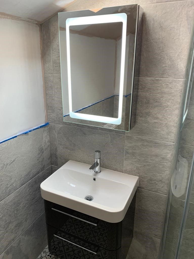 A bathroom with a sink , mirror and cabinet.