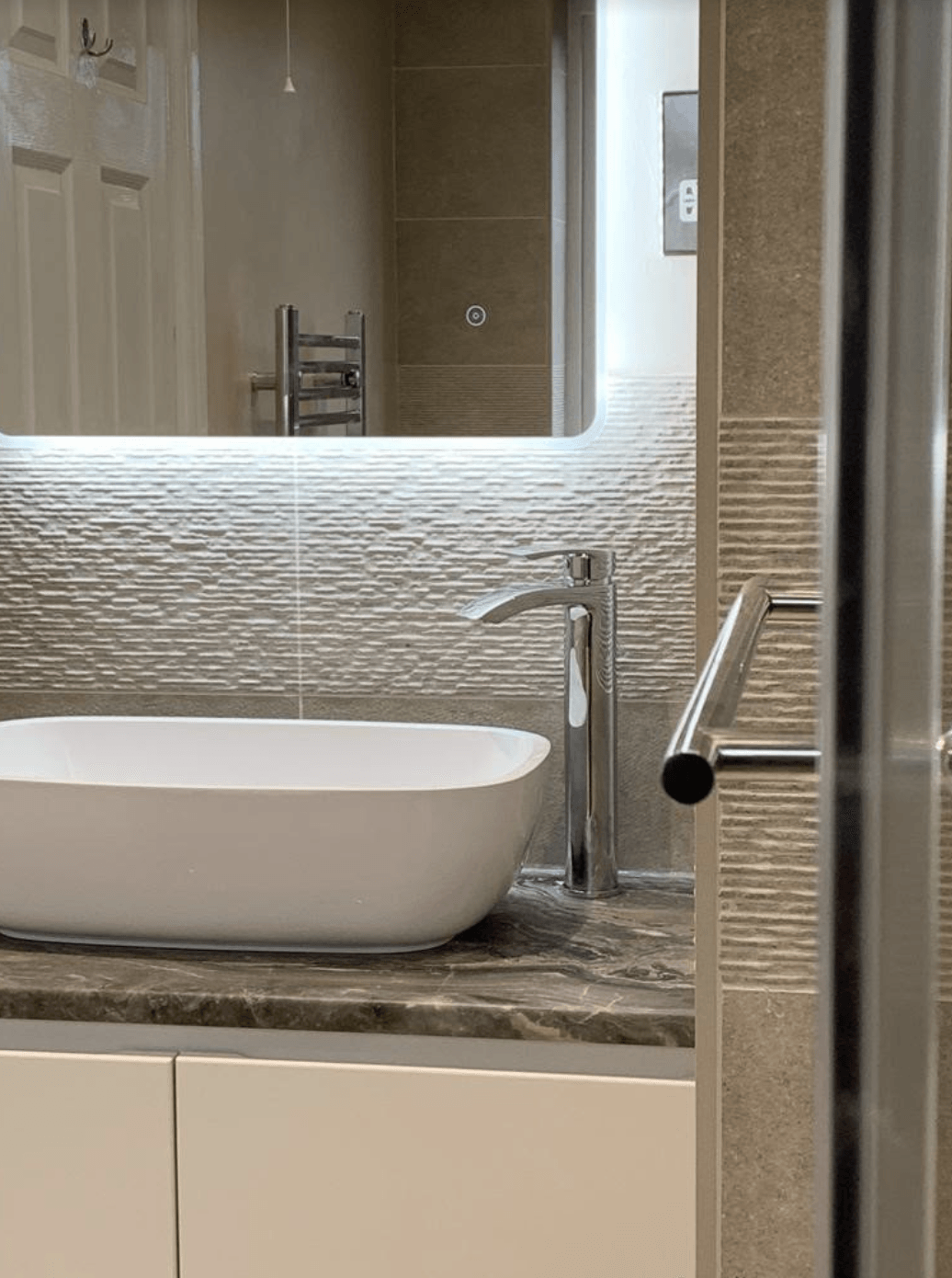 A bathroom with a sink , mirror and towel rack.