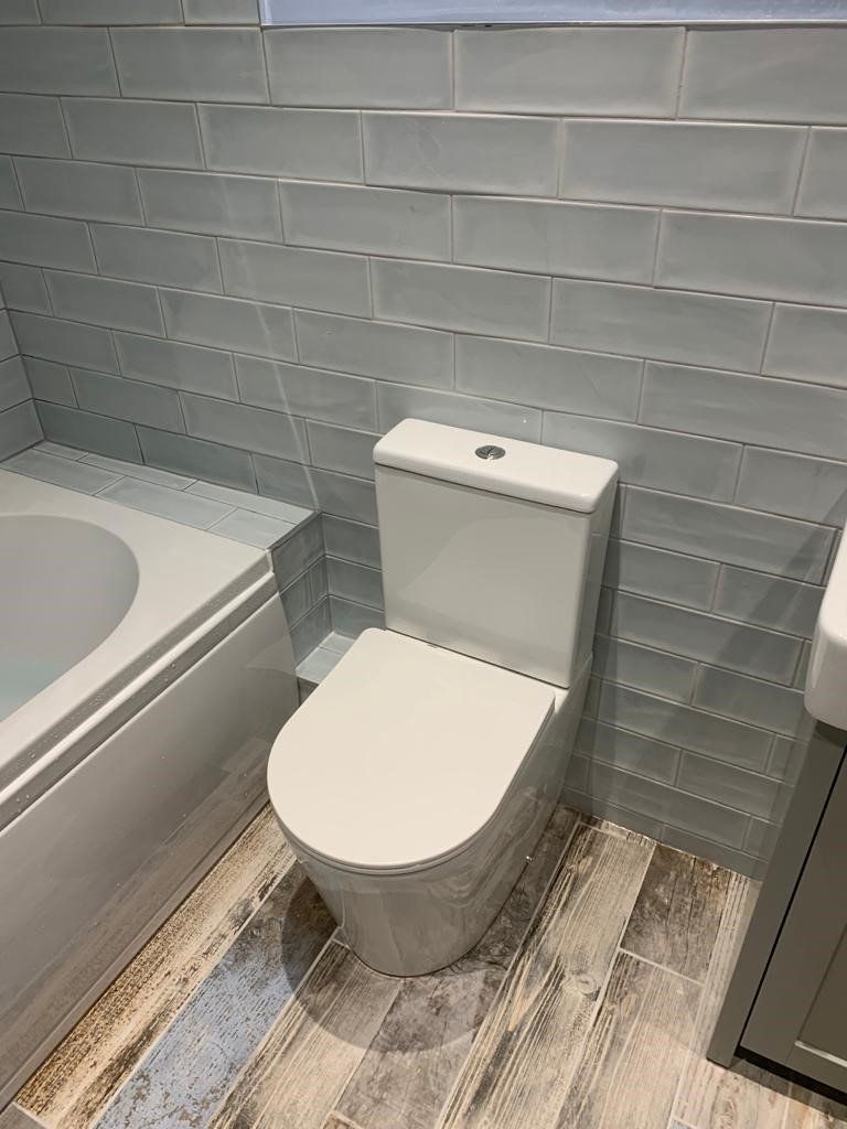 A bathroom with a toilet , bathtub and sink.