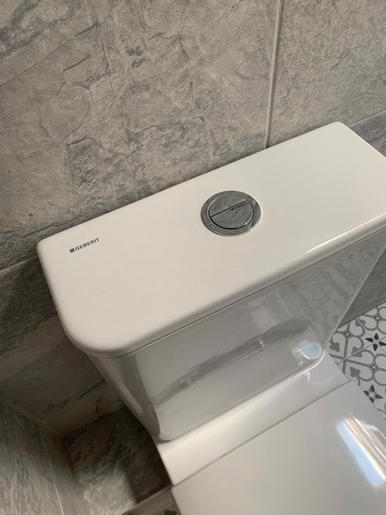 A close up of a toilet tank in a bathroom.