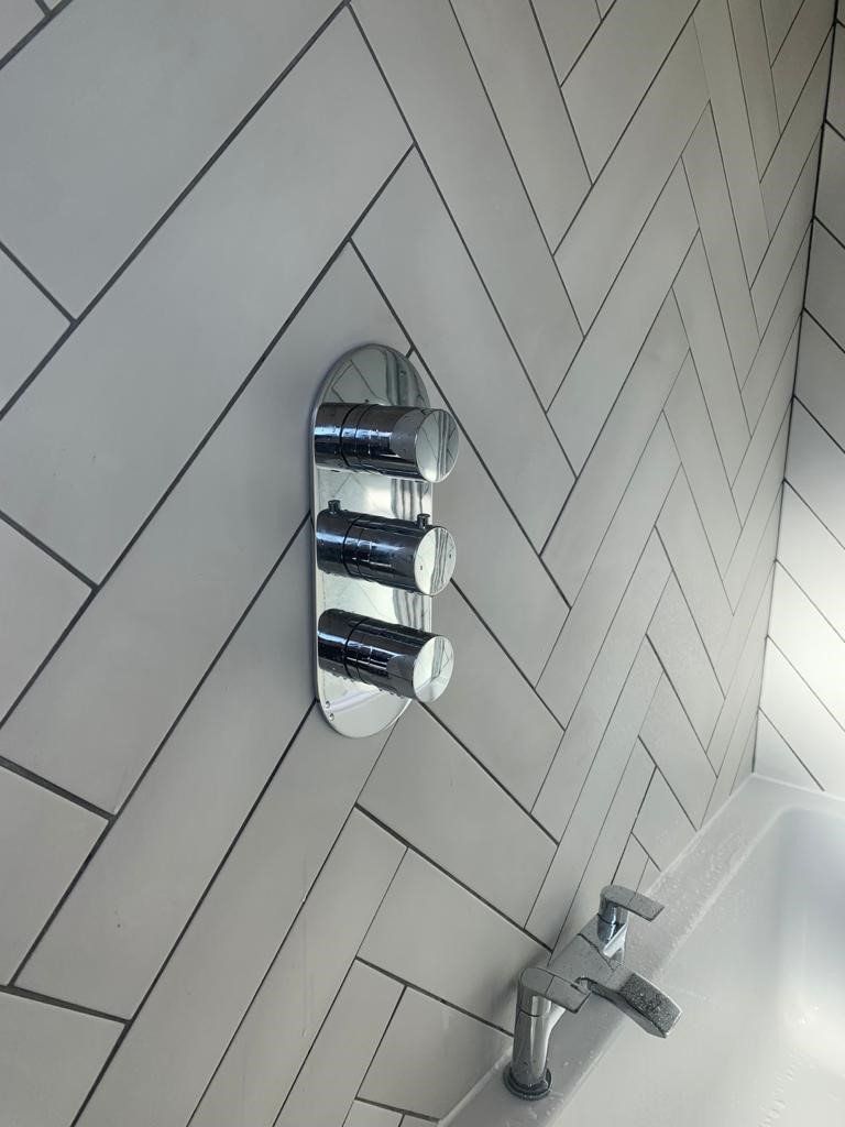 A bathroom with a faucet and a shower head on the wall.