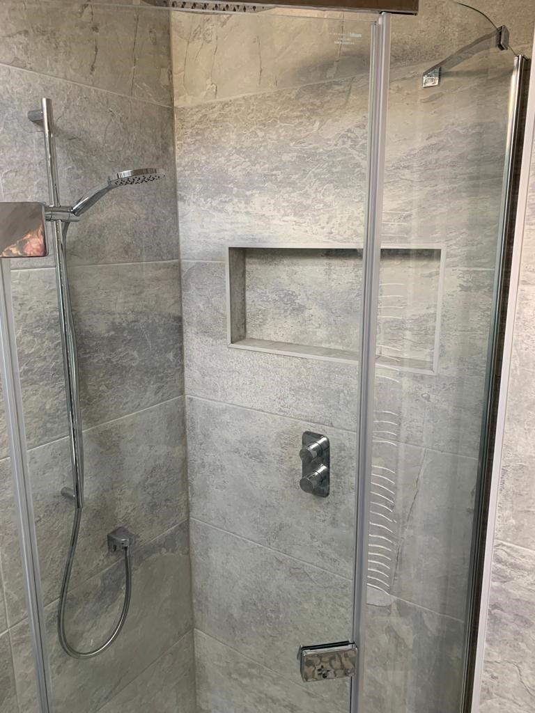 A shower stall with a glass door and a shower head.