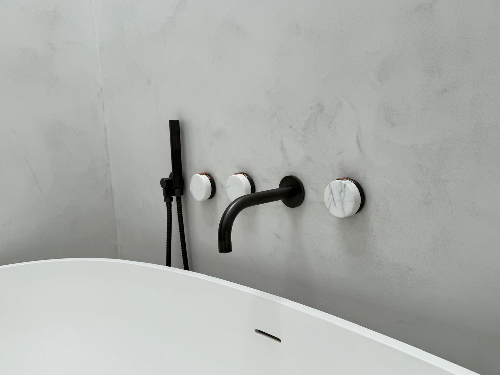 A shower head is spraying water in a bathroom.