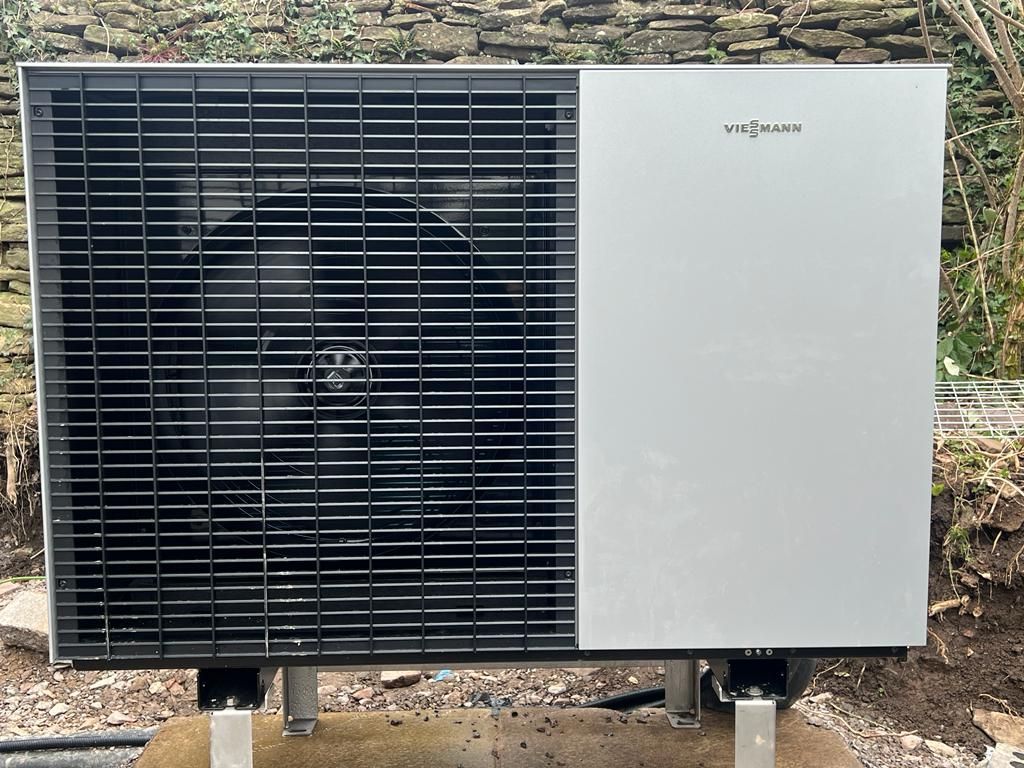 A black and white air conditioner is sitting on top of a wooden table.