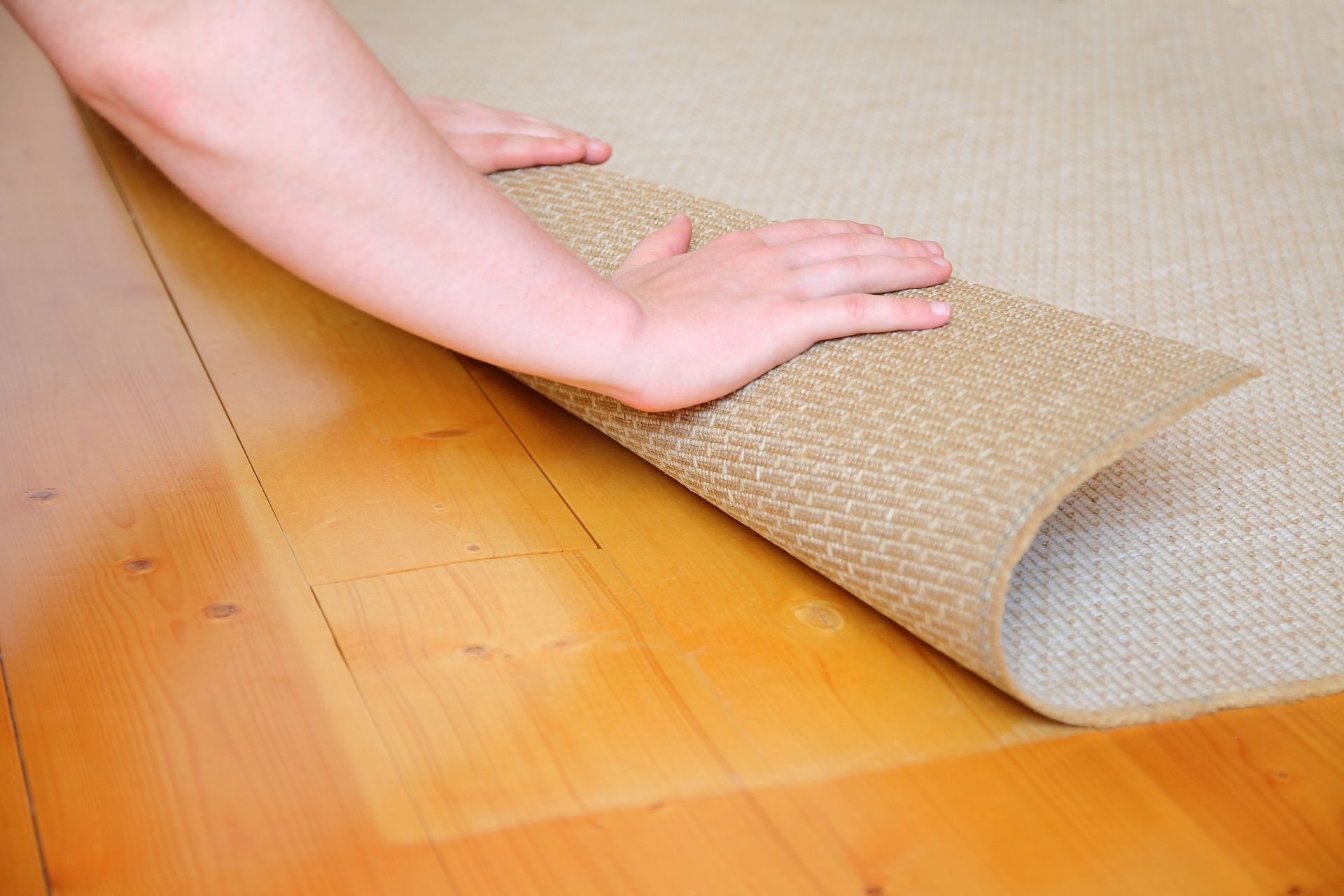 Human hand rolling carpet during spring cleaning.