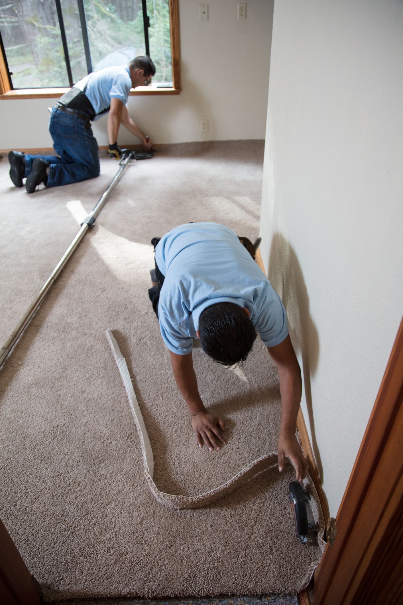Man installing carpeting in home.
