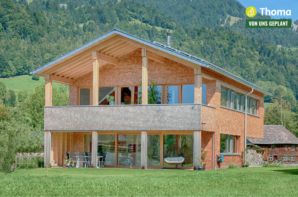 Ein großes Holzhaus mit vielen Fenstern und einem Schild mit der Aufschrift „Thoma“