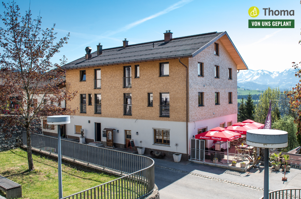 Ein Gebäude mit einem Schild mit der Aufschrift „Thoma“ darauf
