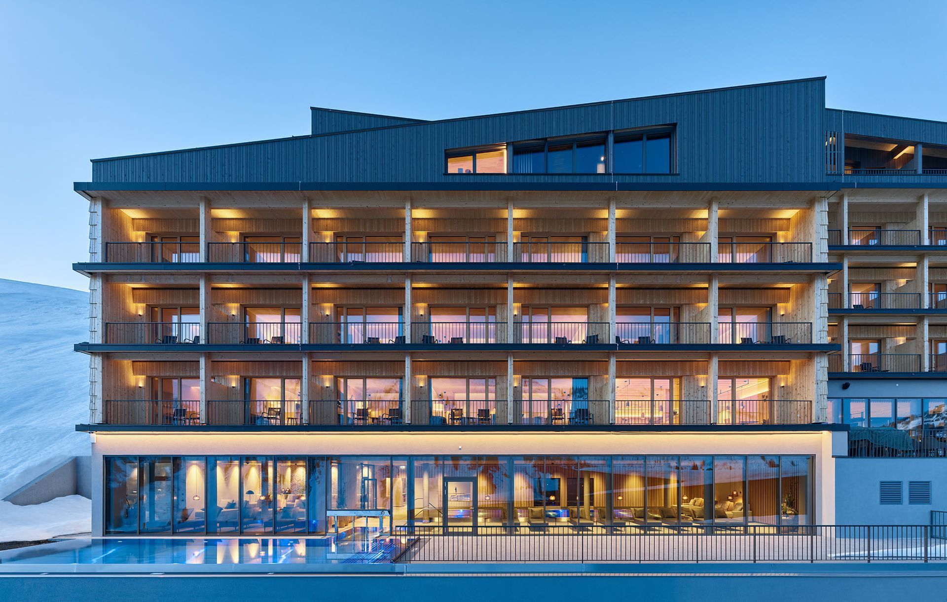 Ein großes Gebäude mit einem Swimmingpool davor.